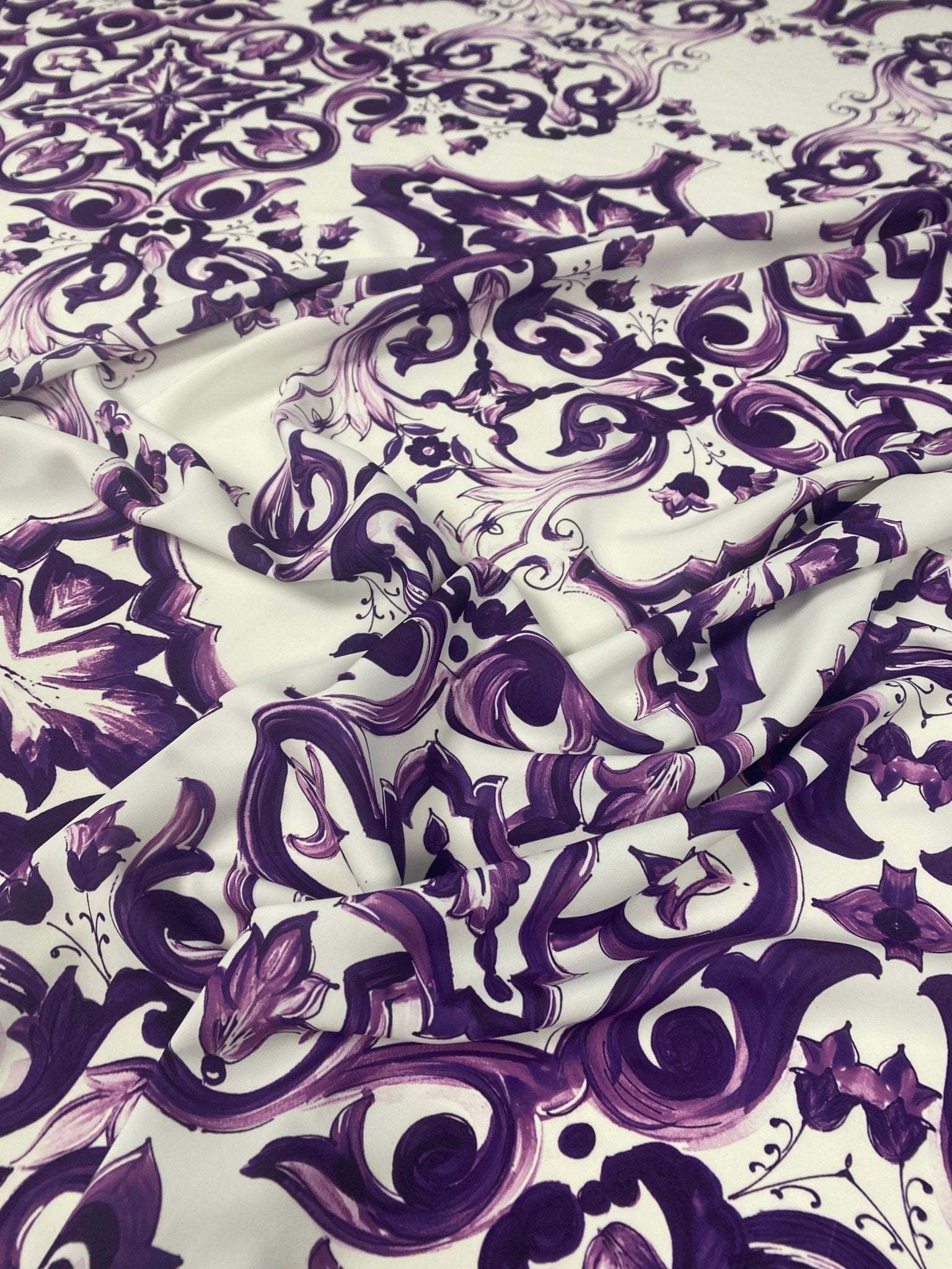Purple Baroque floral pattern fabric with intricate purple and white design, ideal for upholstery and crafting.