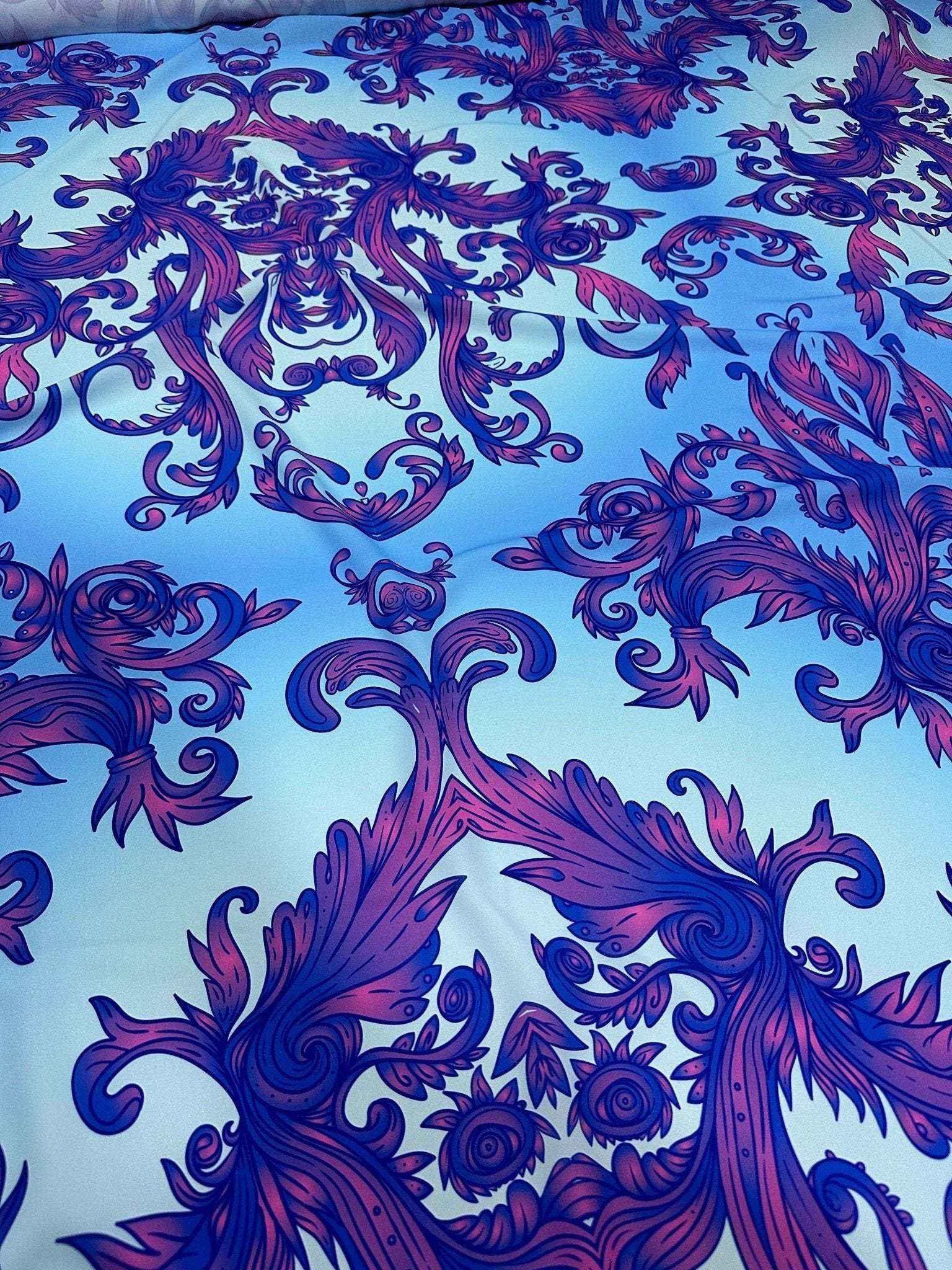 Purple and blue baroque patterned fabric with ornate floral design and vibrant hues, ideal for upholstery and crafting projects