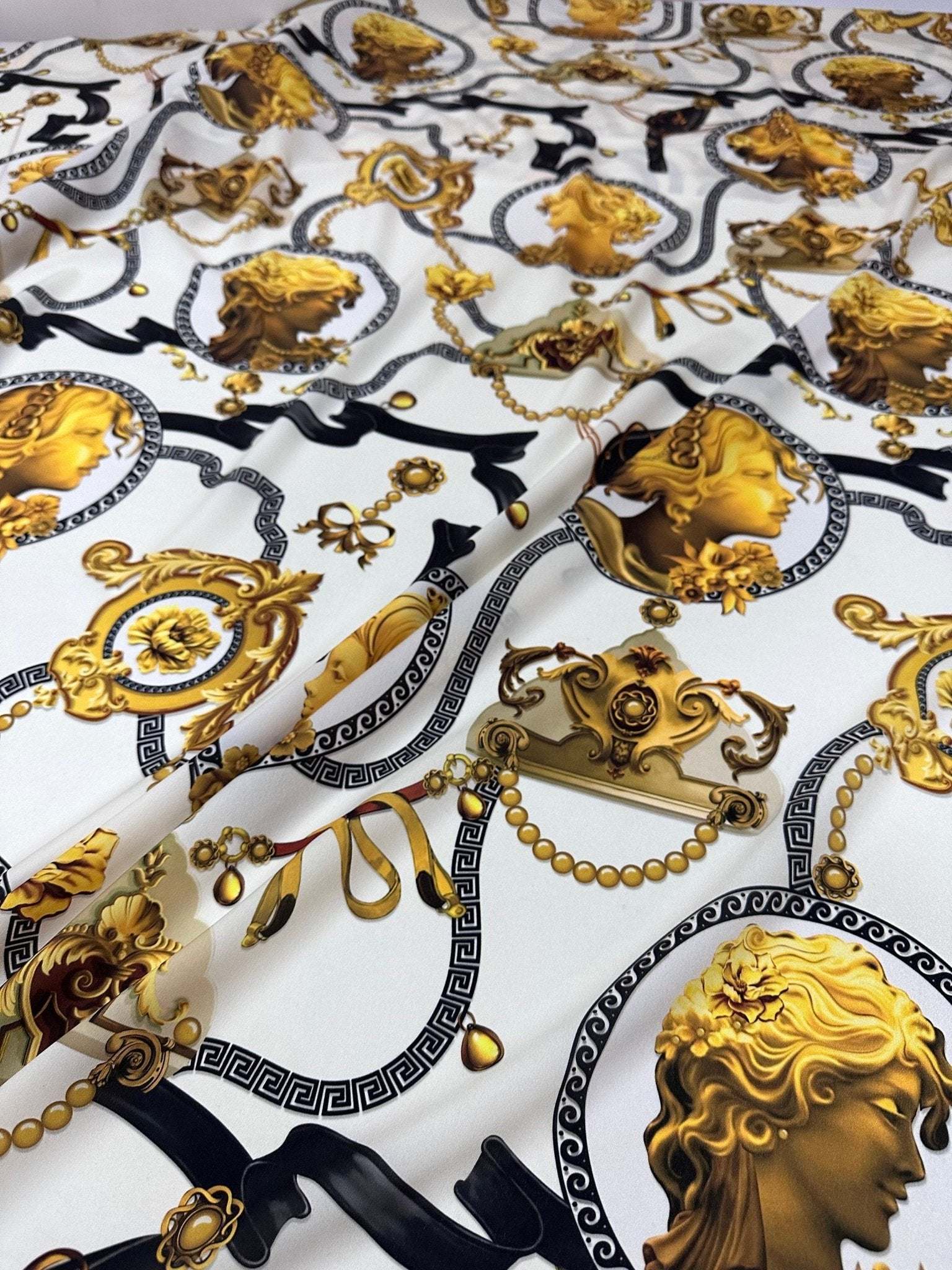 Queen and Rome pattern crepe fabric with gold classical motifs on white background, 150cm wide textile for elegant sewing projects