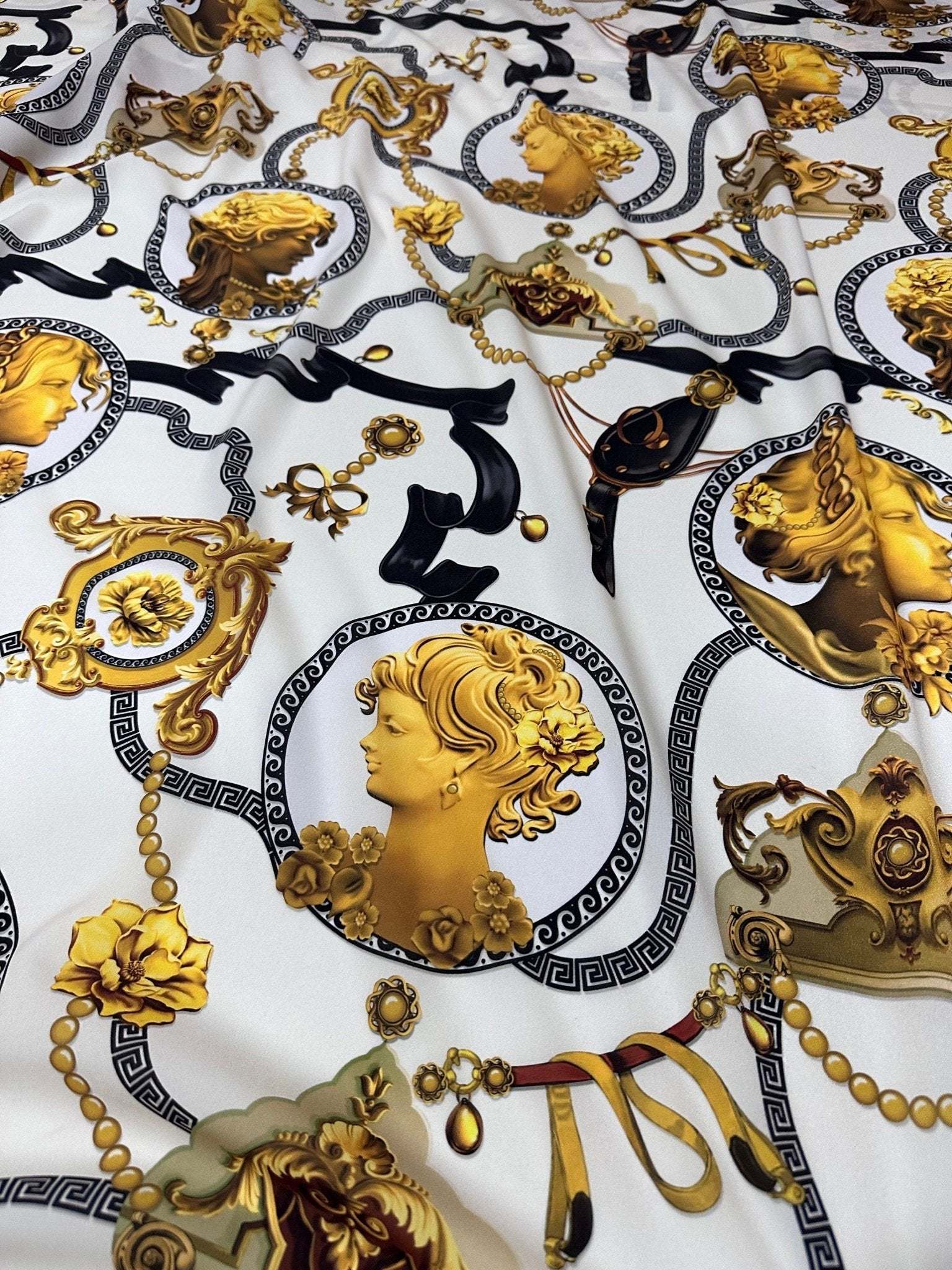 Queen and Rome pattern crepe fabric with intricate gold classical portraits and decorative motifs on white background