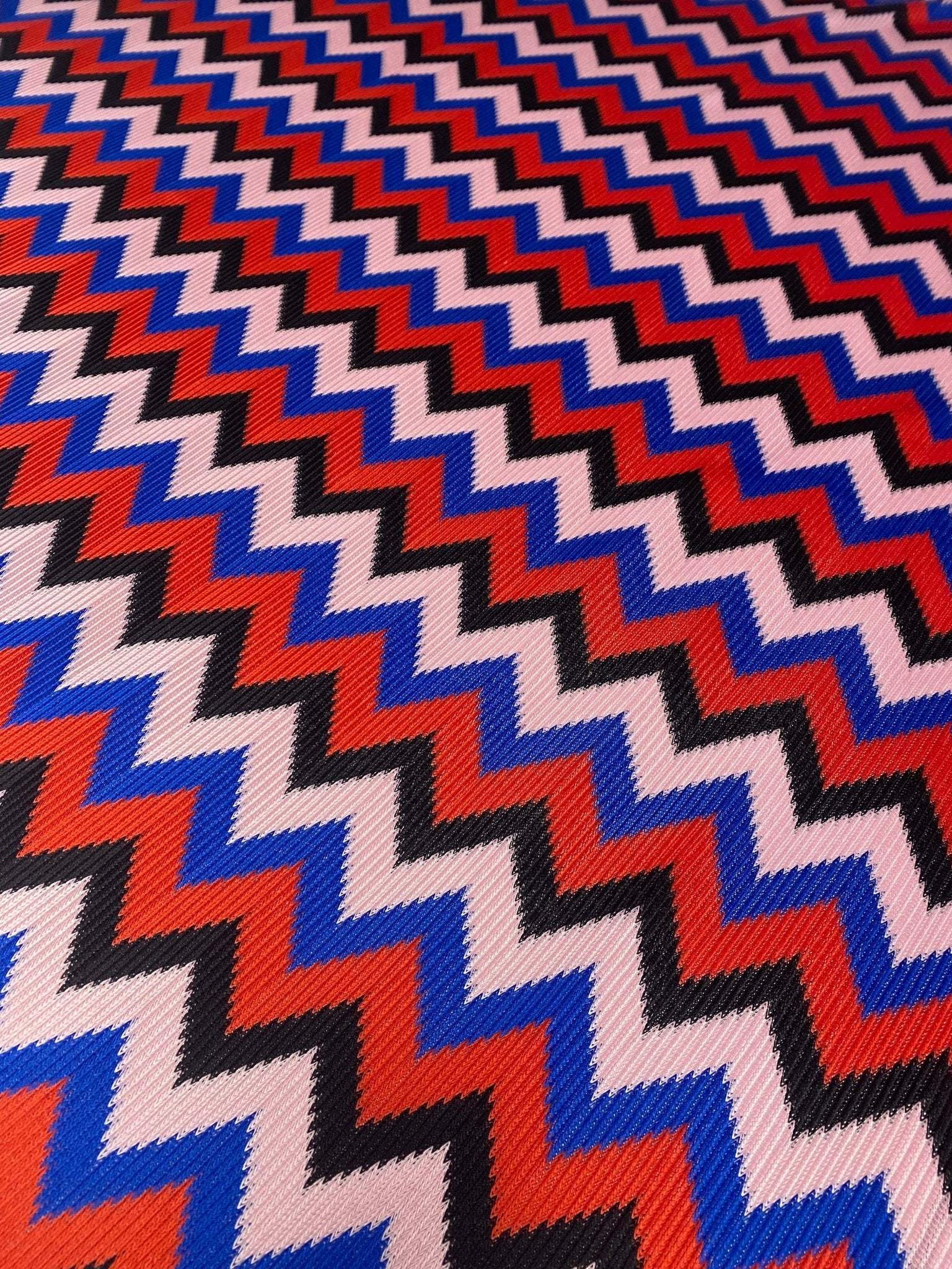 Red blue black zigzag chevron pattern knit fabric close-up texture