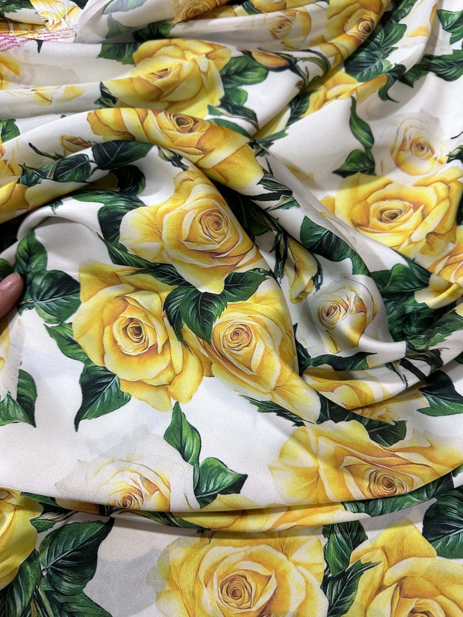 Yellow floral rose pattern fabric with green leaves on white background for sewing and crafting projects