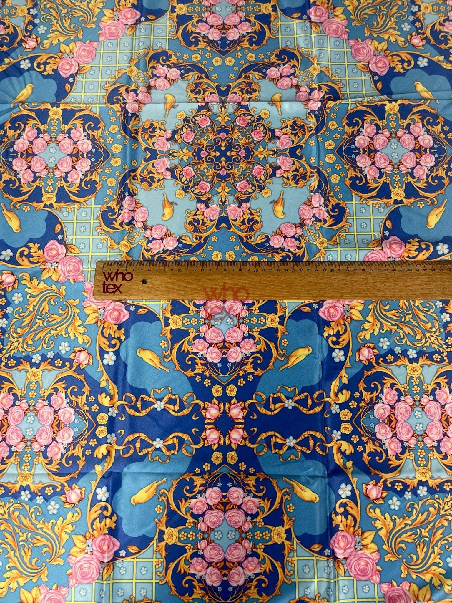 Royal blue ornate fabric with pink roses, birds, and gold scroll patterns