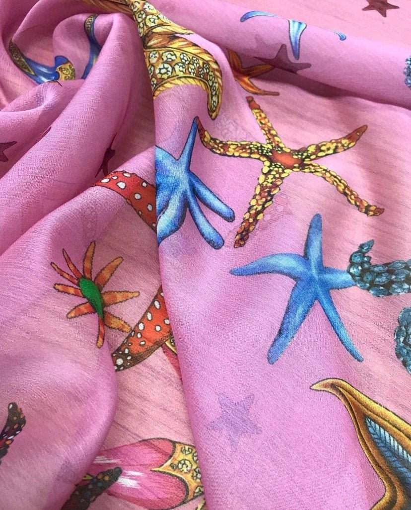 Pink sugar chiffon fabric with colorful sea shell pattern including starfish and coral designs