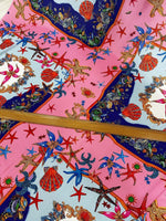 Bright coastal sea shell fabric with starfish and seashell patterns on pink and blue background