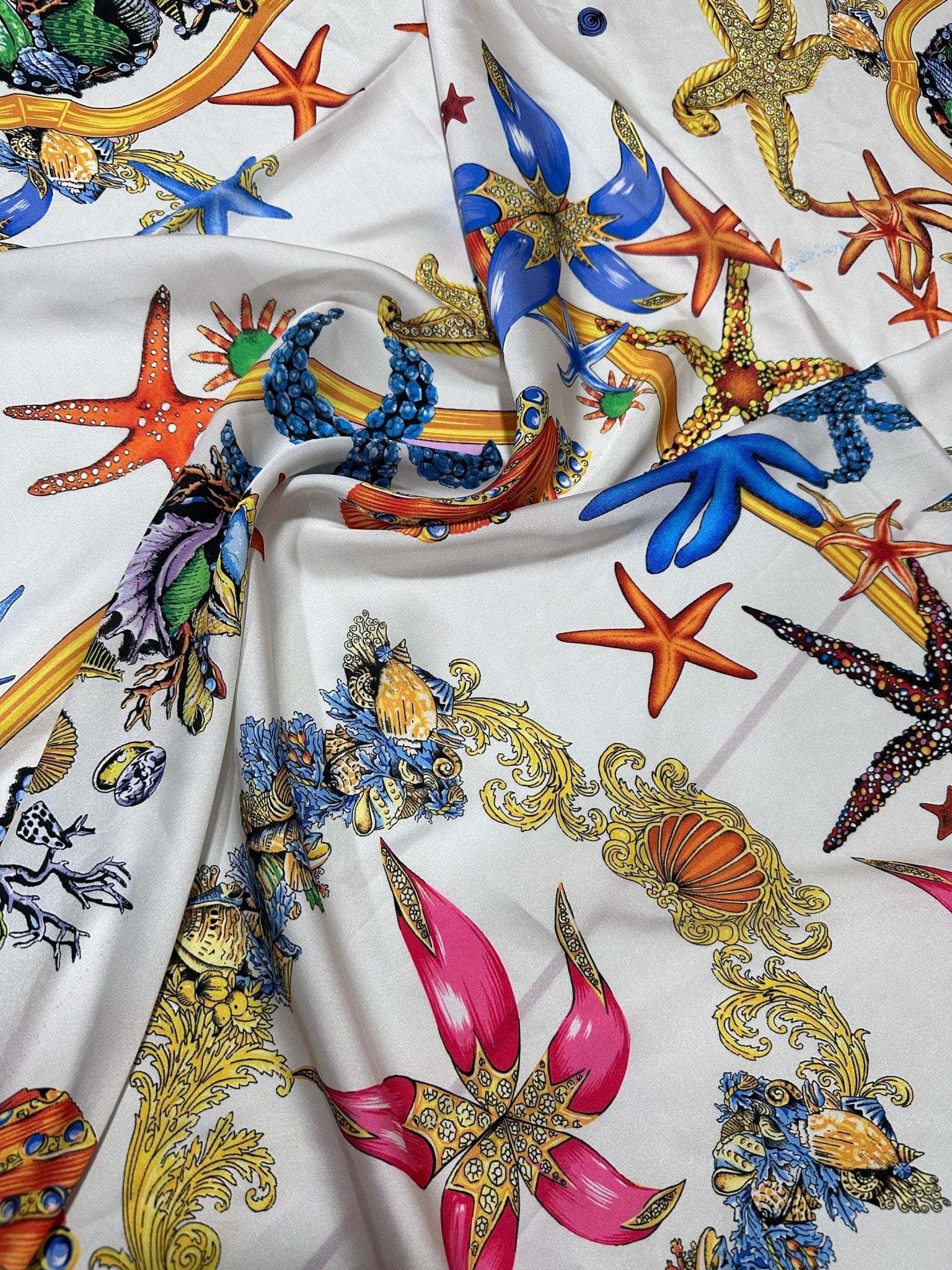 White fabric with colorful sea shell and starfish pattern for sewing projects