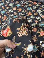 Fabric with sea shell and starfish pattern on black background for beach-themed crafts and decor