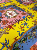 Bright coastal fabric with sea shells and starfish pattern in yellow, pink, and blue colors