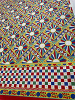 Sicilian Caretto Upholstery Fabric with vibrant geometric and floral patterns in red, blue, yellow, and white for decorative home use