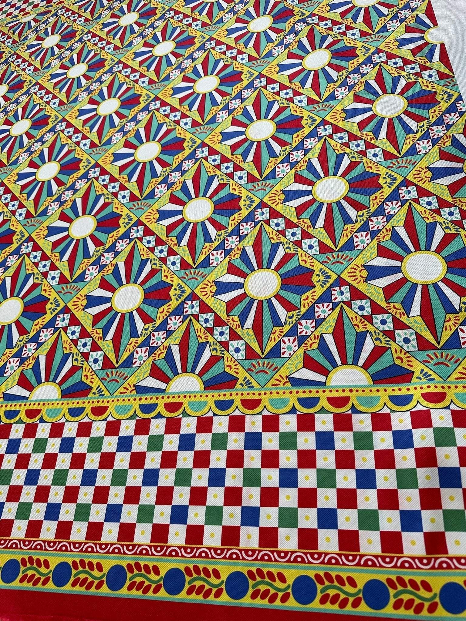 Sicilian Caretto Upholstery Fabric with vibrant geometric and floral patterns in red, blue, yellow, and white for decorative home use