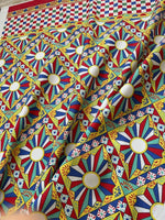Sicilian Caretto Upholstery Fabric with colorful geometric and floral patterns in red, blue, yellow, and white for decorative use