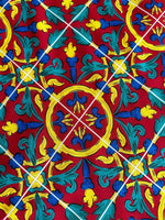 Close-up of Sicilian pattern on bordeaux fabric with yellow, blue, and green decorative elements
