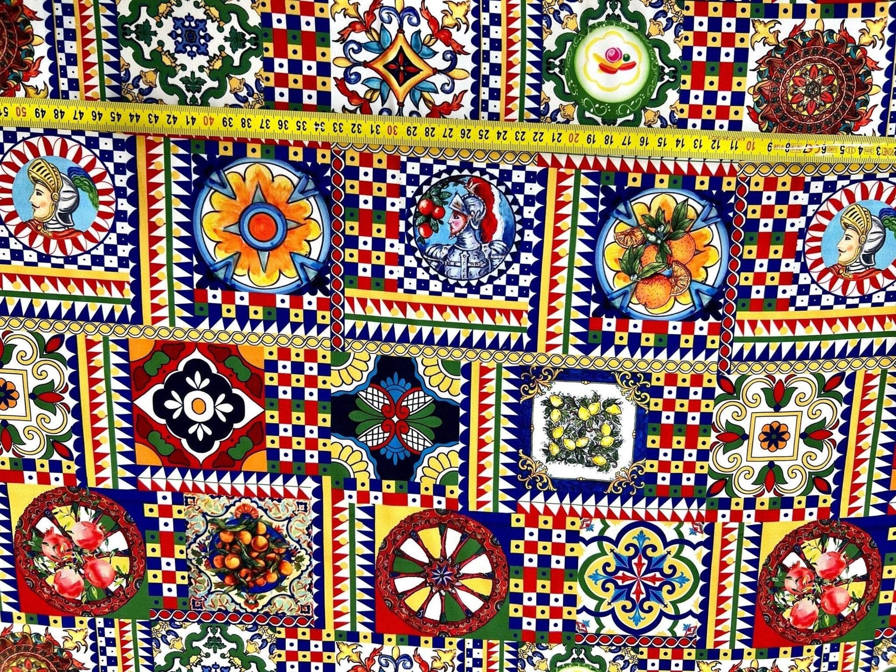 Sicilian Pattern Italian Fabric with vibrant multicolor geometric and floral designs, featuring traditional motifs and a measuring tape showing fabric width.