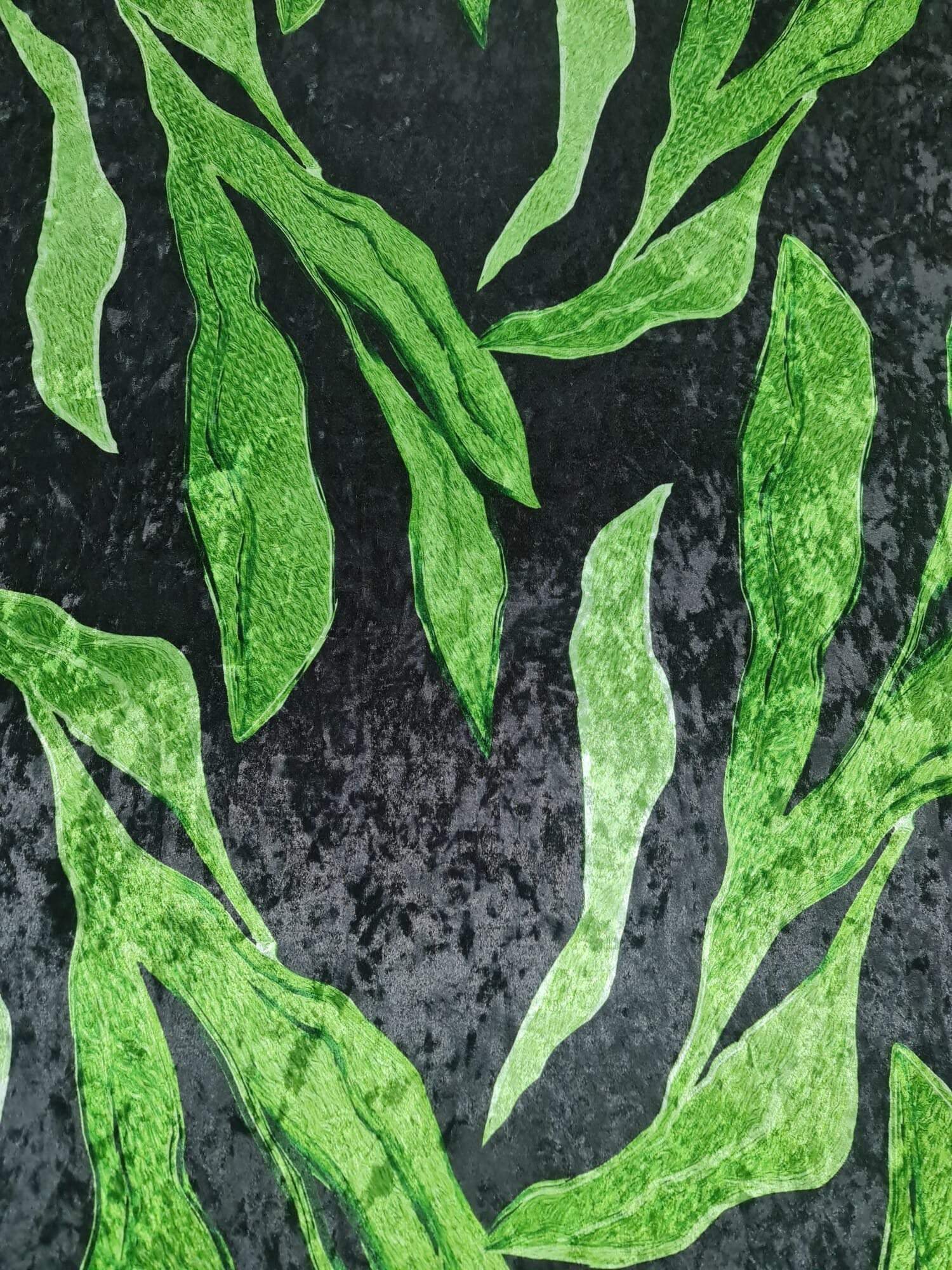 silky velvet fabric with green leaf pattern on black background, lightweight lycra blend textile for clothing and decor