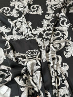 Luxurious silver baroque fabric with intricate elegant patterns on black background for upholstery and drapery projects