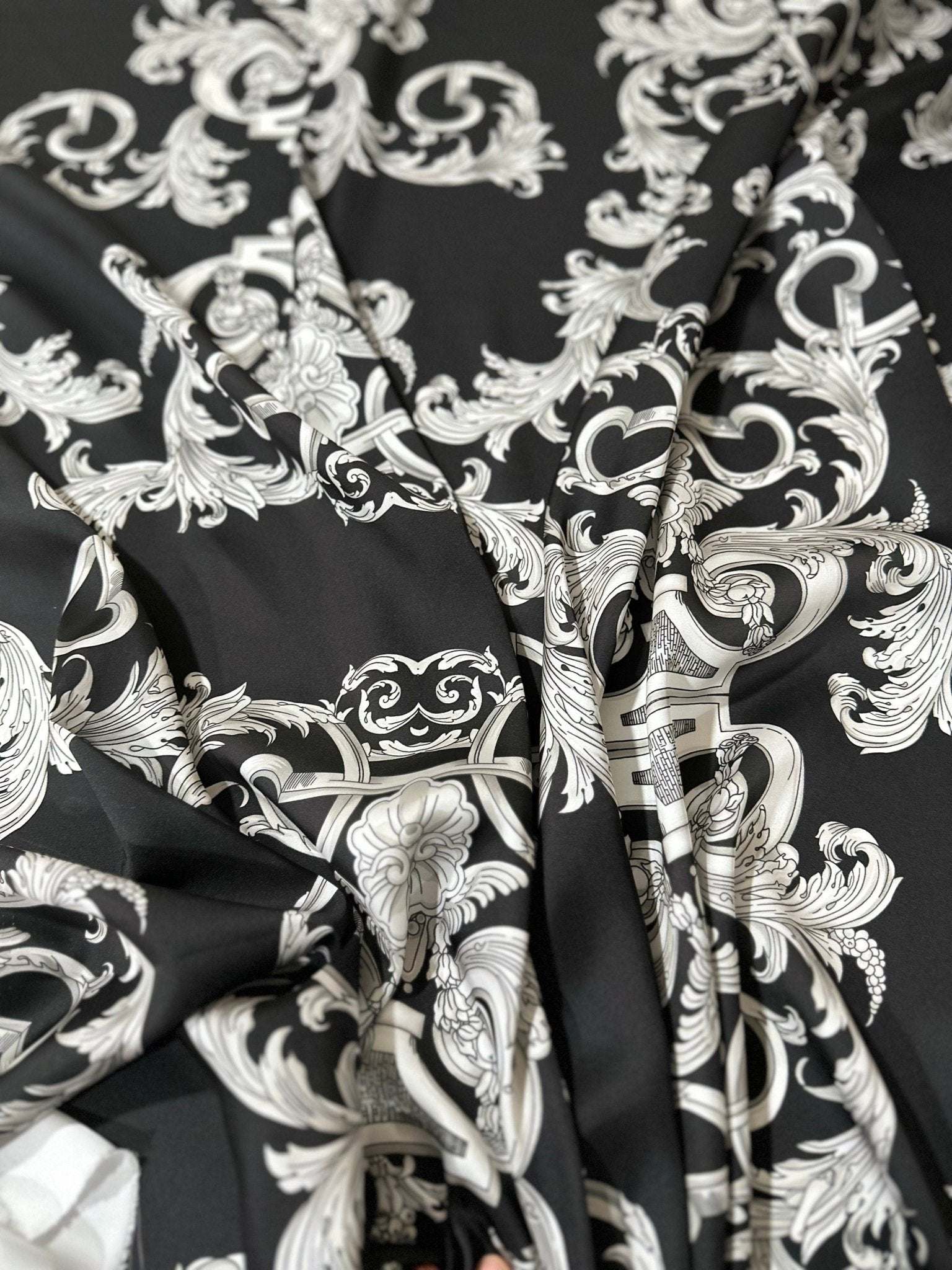 Luxurious silver baroque fabric with intricate elegant patterns on black background for upholstery and drapery projects