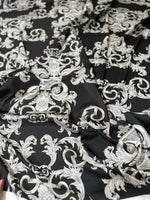 Luxurious black fabric with intricate silver baroque pattern and rich texture for upholstery and drapery projects