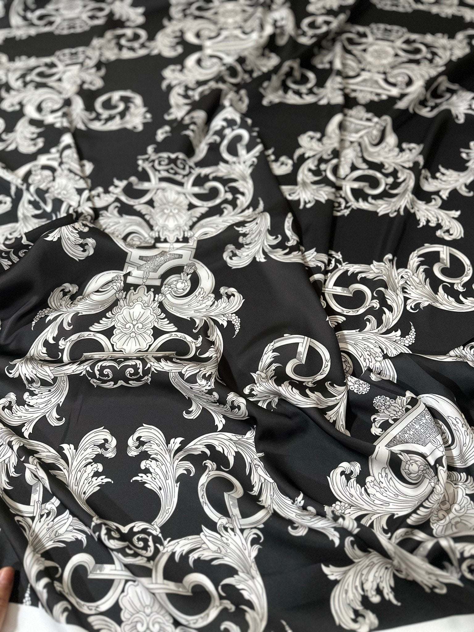 Luxurious black fabric with intricate silver baroque pattern and rich texture for upholstery and drapery projects
