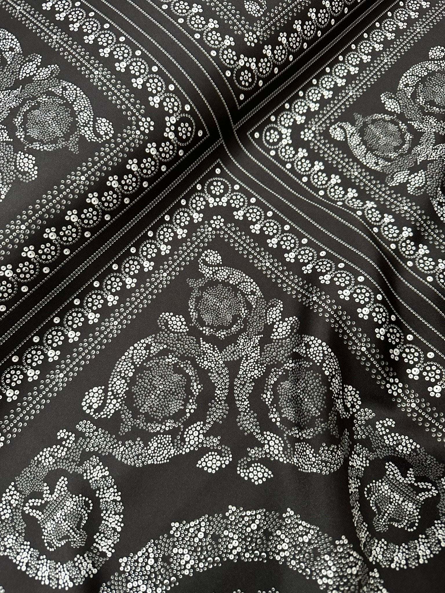 Baroque silver upholstery fabric with intricate floral and ornamental patterns on dark background