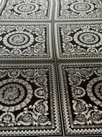 Baroque silver upholstery fabric with intricate decorative pattern in square panels on dark background