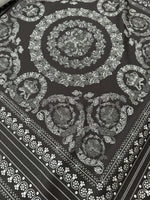 Baroque silver upholstery fabric with intricate floral and circular pattern on dark background