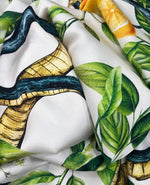Close-up of Snake and Lemon Fabric with snake, lemon slices, and green leaf prints on white background.