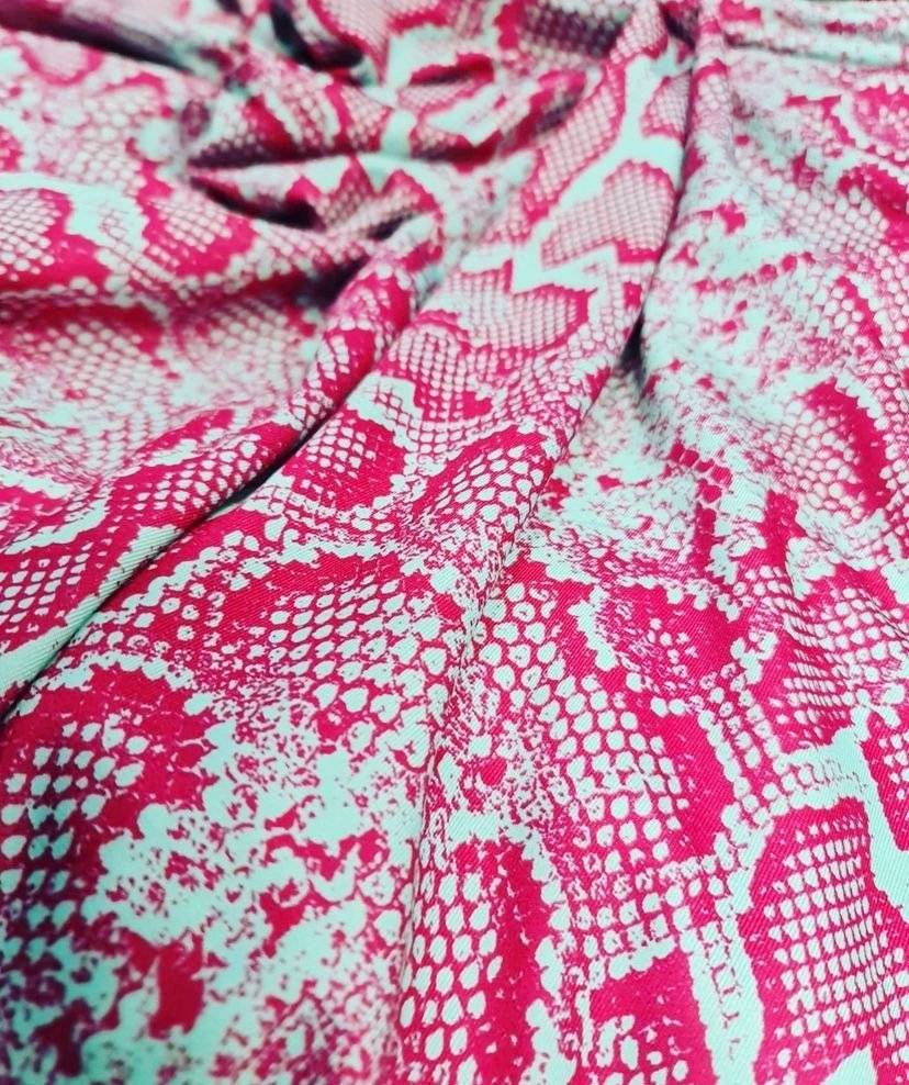 Close-up of pink and white snake skin fabric with vibrant animal print pattern