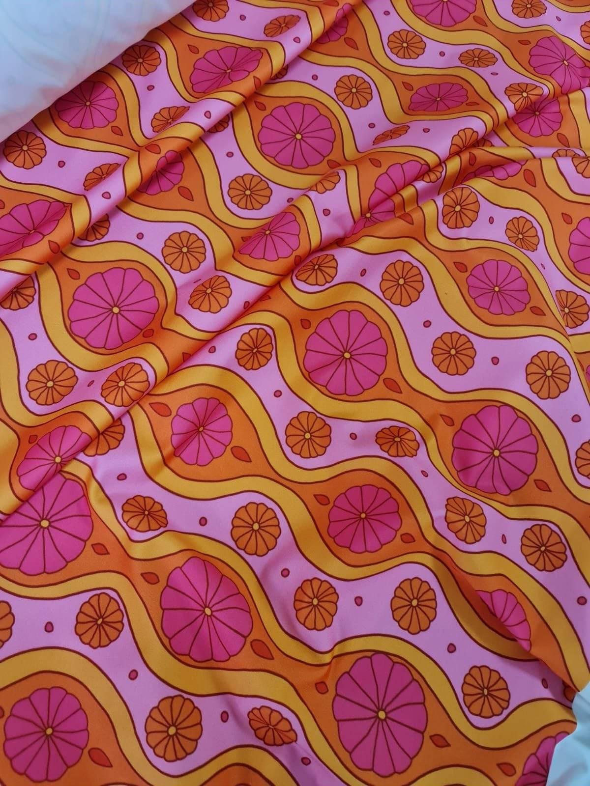 Pink geometric pattern floral spandex fabric with vibrant orange and pink floral designs and wavy lines