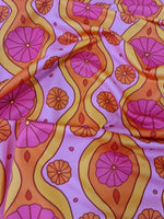 Pink geometric pattern floral spandex fabric with orange and yellow accents, 150cm wide textile for sewing projects