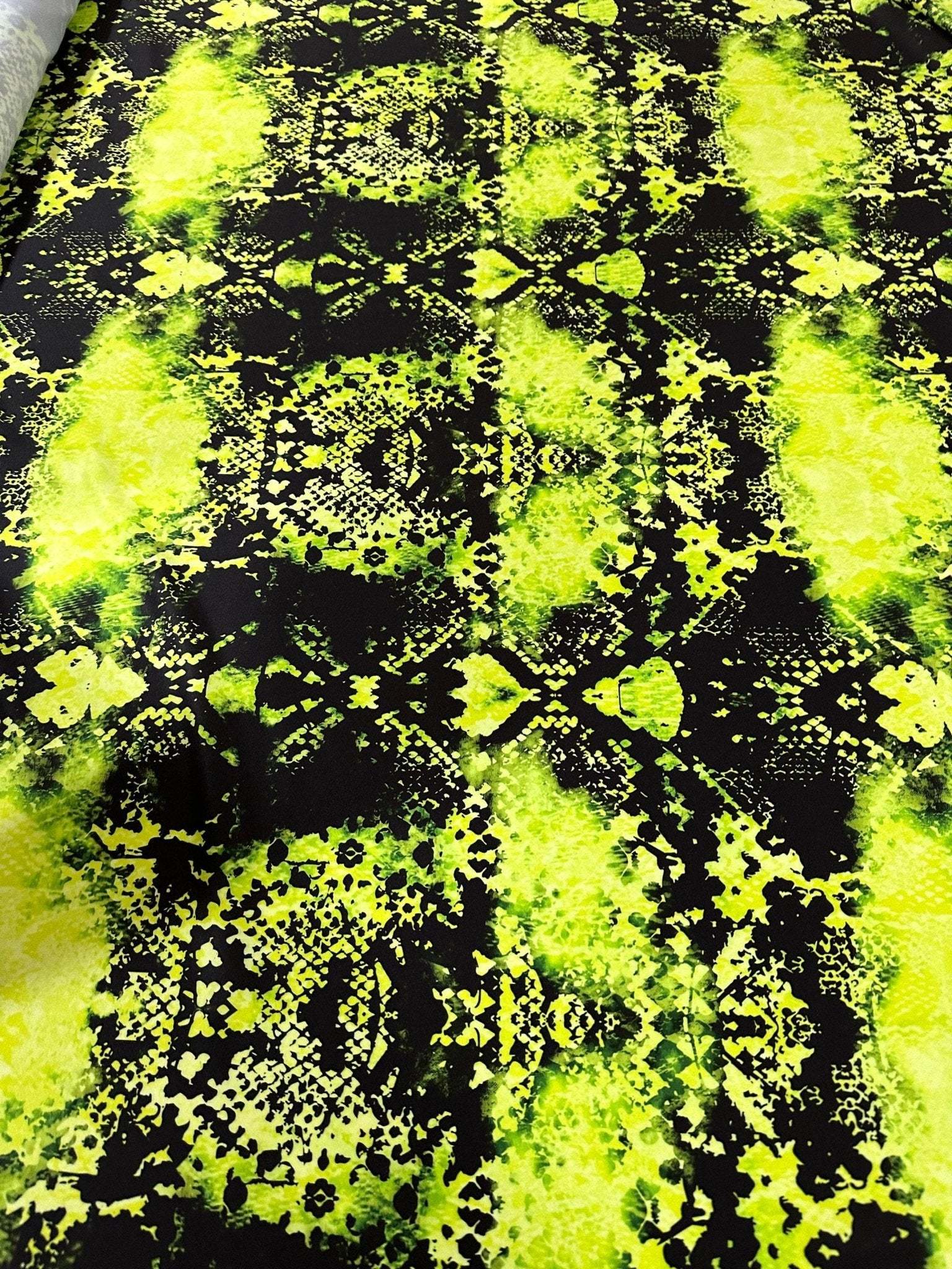 Neon green spandex fabric with black abstract pattern, stretchy material for activewear and costumes