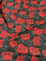 Elegant red rose patterned spandex fabric on black background with floral design and stretch texture