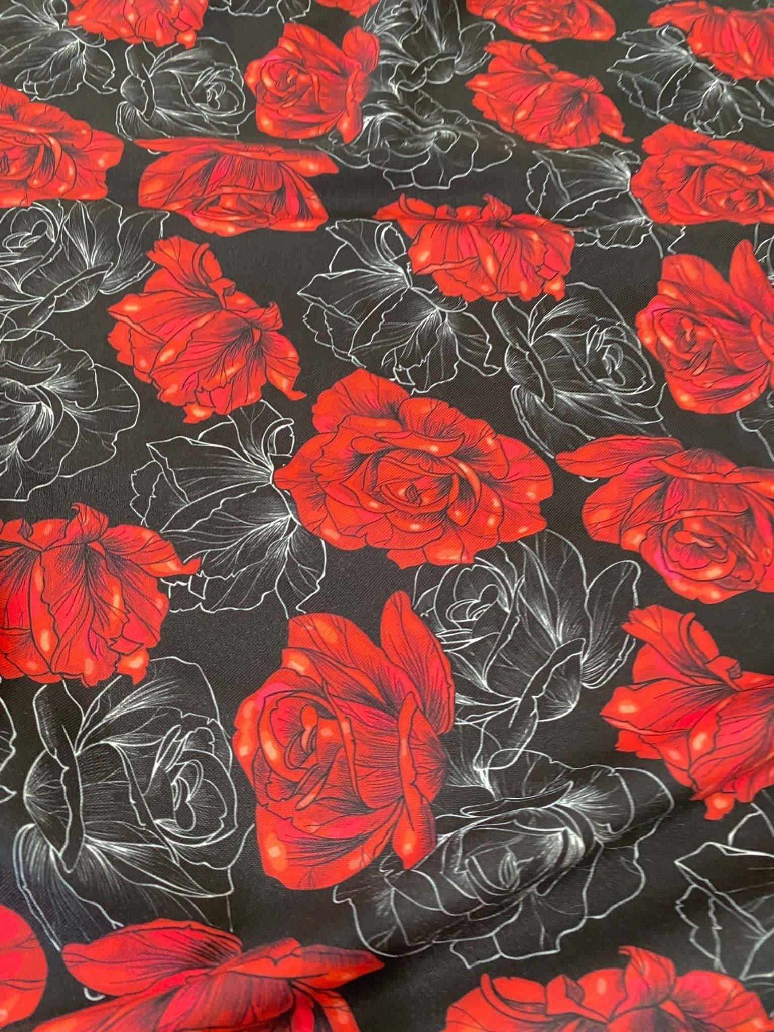 Elegant red rose patterned spandex fabric with floral design on black background, 150cm wide, stretchy and versatile for sewing projects.