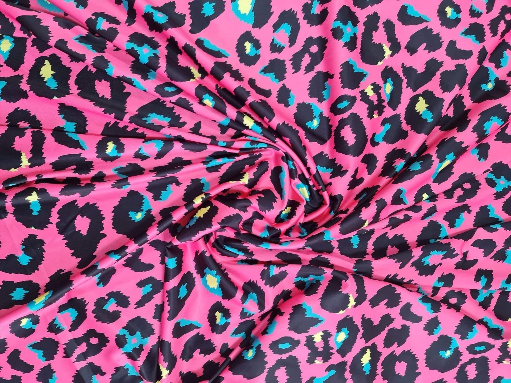 Sugar pink leopard print fabric with vibrant blue and yellow accents, 150cm wide, suitable for clothing and crafts