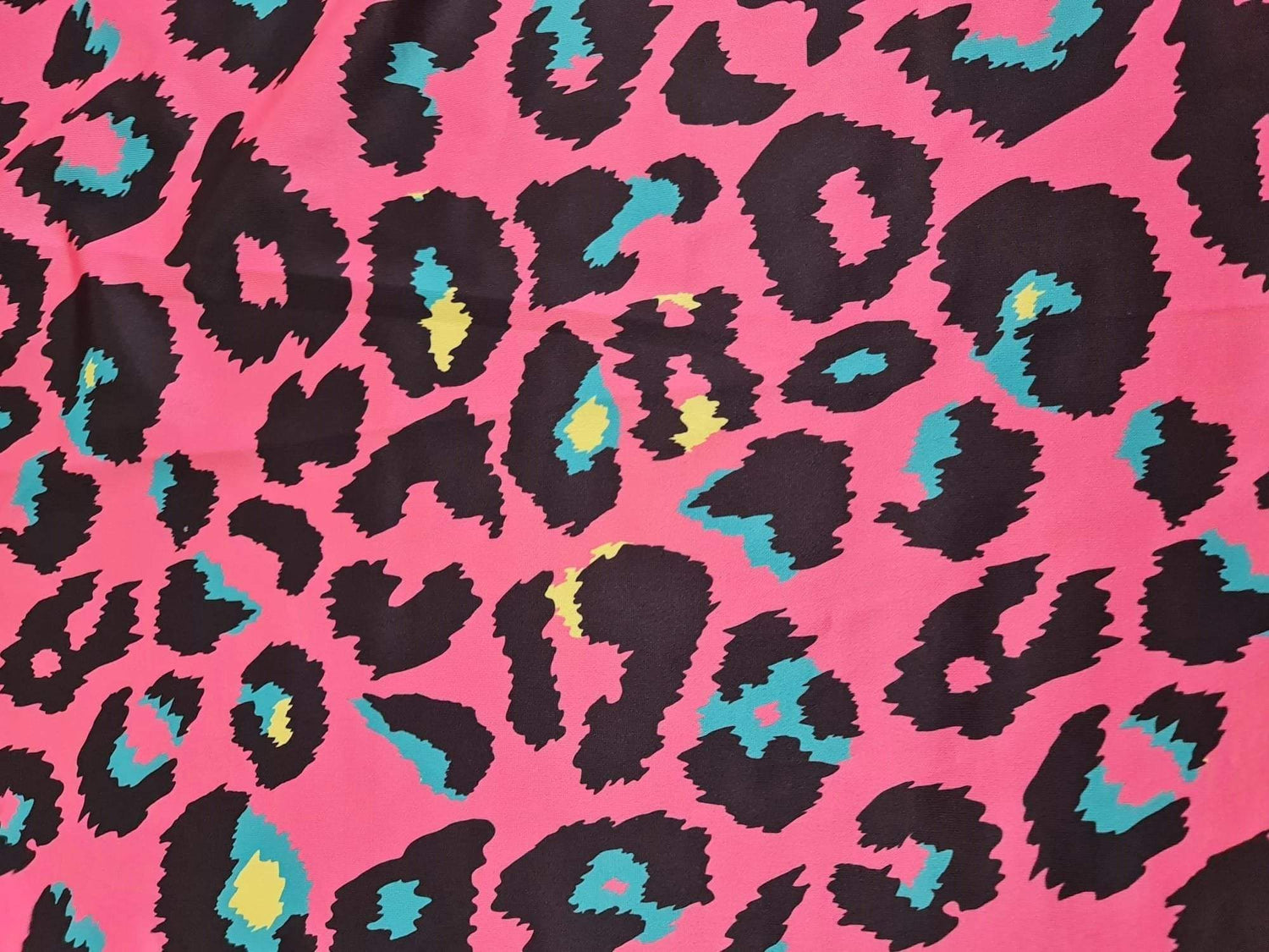 Sugar pink leopard print fabric with black and teal accents, 150cm width, bold animal pattern textile for clothing and decor projects