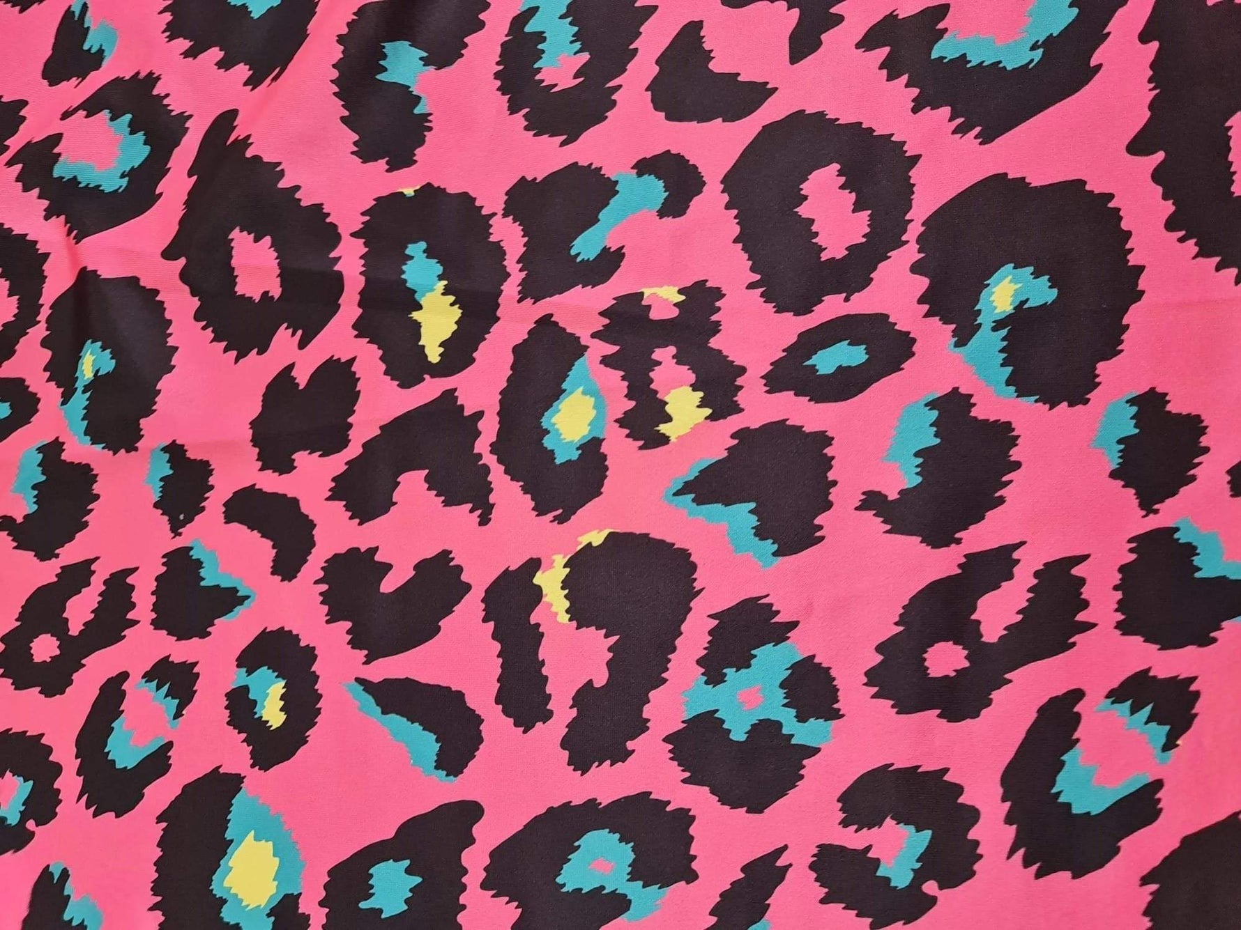 Sugar pink leopard print fabric with black and teal accents, 150cm width, bold animal pattern textile for clothing and decor projects