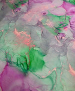 Abstract watercolor print fabric with vibrant green, pink, and purple tie dye design for sewing and crafts