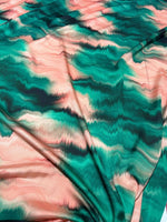 Green and pink pattern tie dye fabric with vibrant, wavy design and soft texture