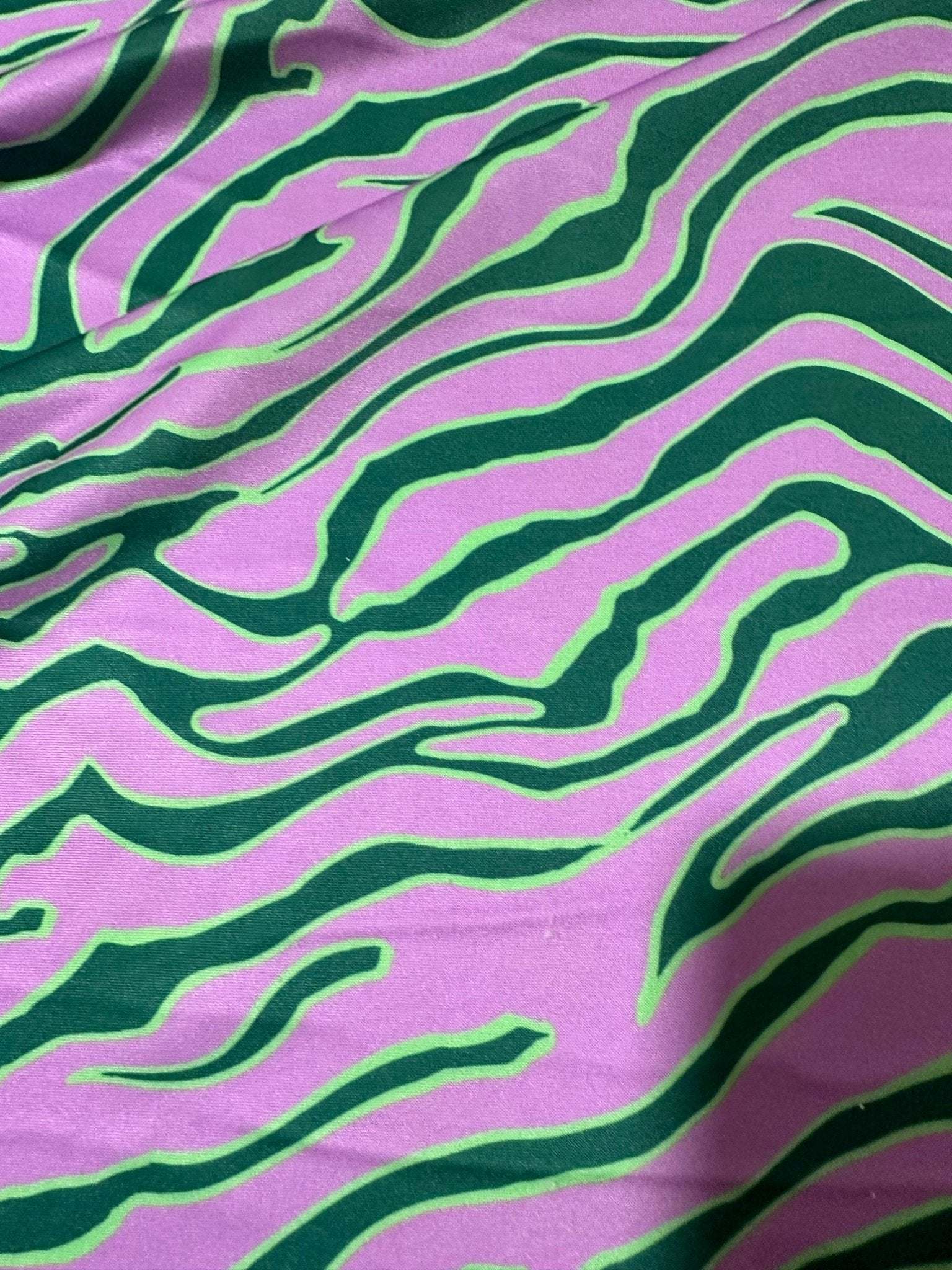 Exotic tiger pattern fabric in vibrant green and purple with 150cm width for clothing and home décor projects