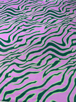 Exotic tiger pattern fabric in vibrant green and purple with bold animal print design
