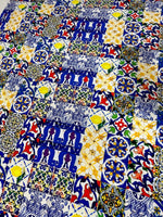 Colorful tile pattern fabric with blue, yellow, red, and green intricate designs, perfect for sewing and crafting projects