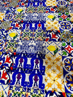 Colorful tile pattern fabric with blue, yellow, red, and white designs, ideal for quilting and crafting projects