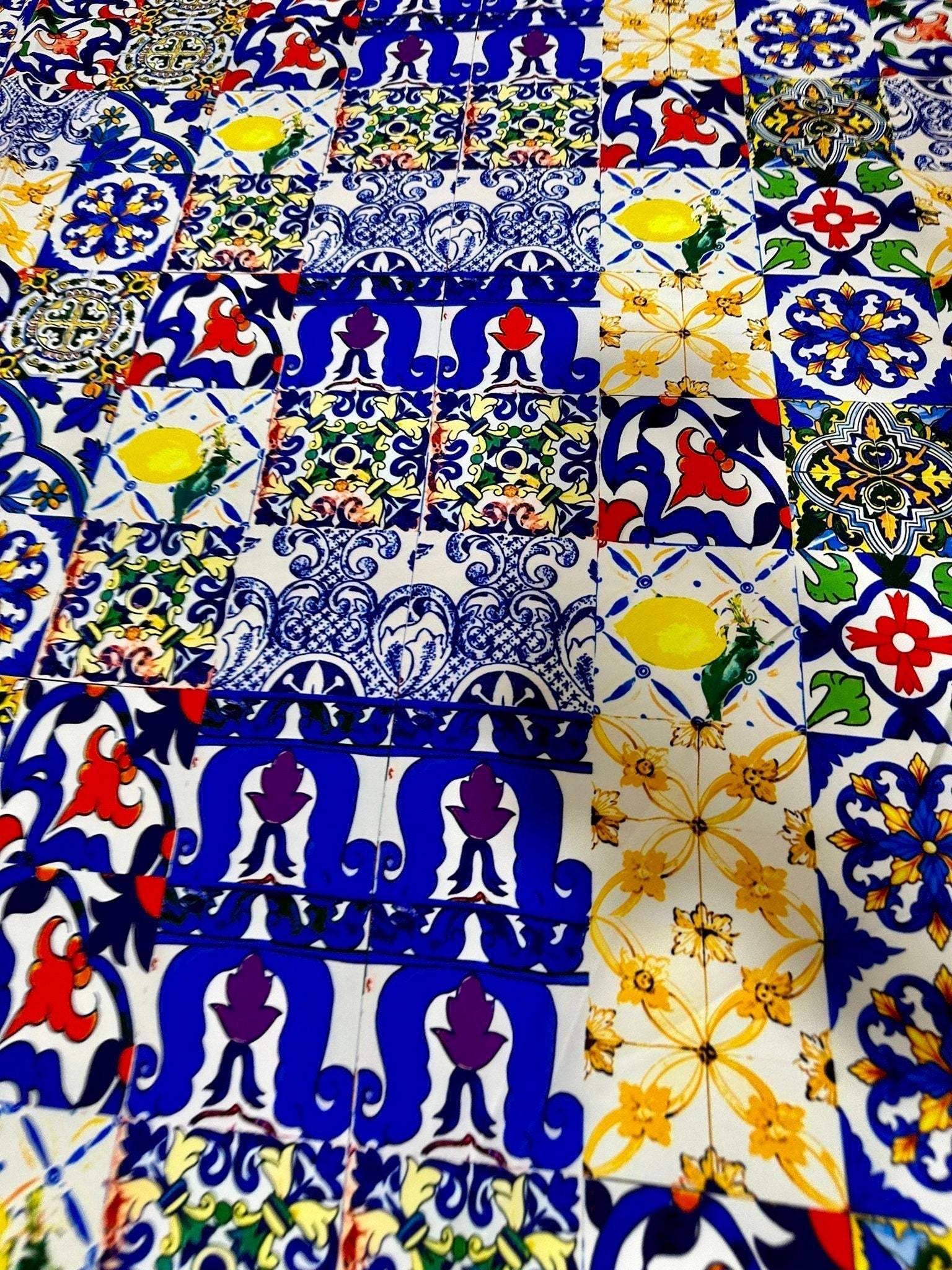 Colorful tile pattern fabric with blue, yellow, red, and white designs, ideal for quilting and crafting projects