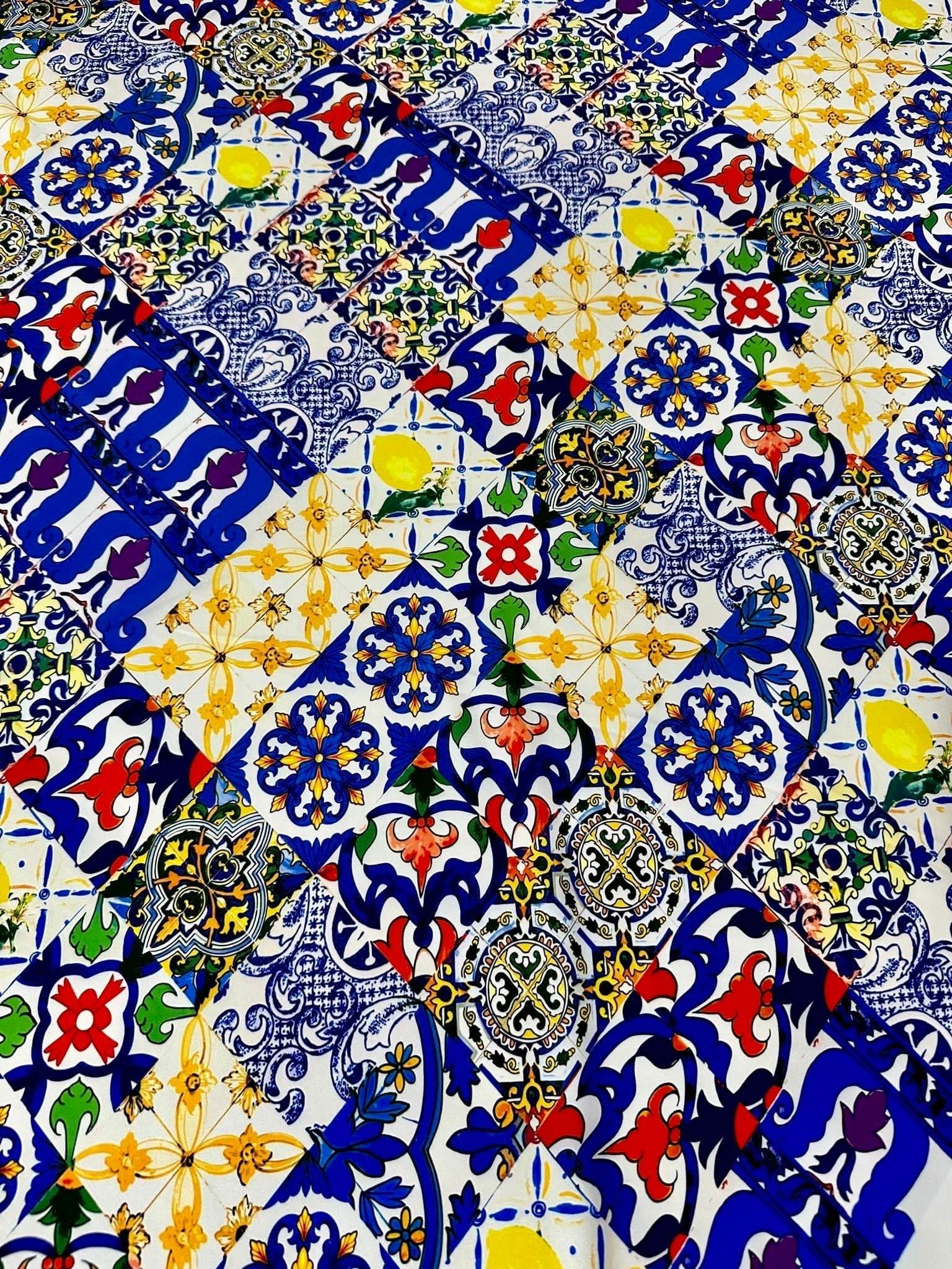 Close-up of colorful tile pattern fabric with blue, yellow, red, and green designs on white background