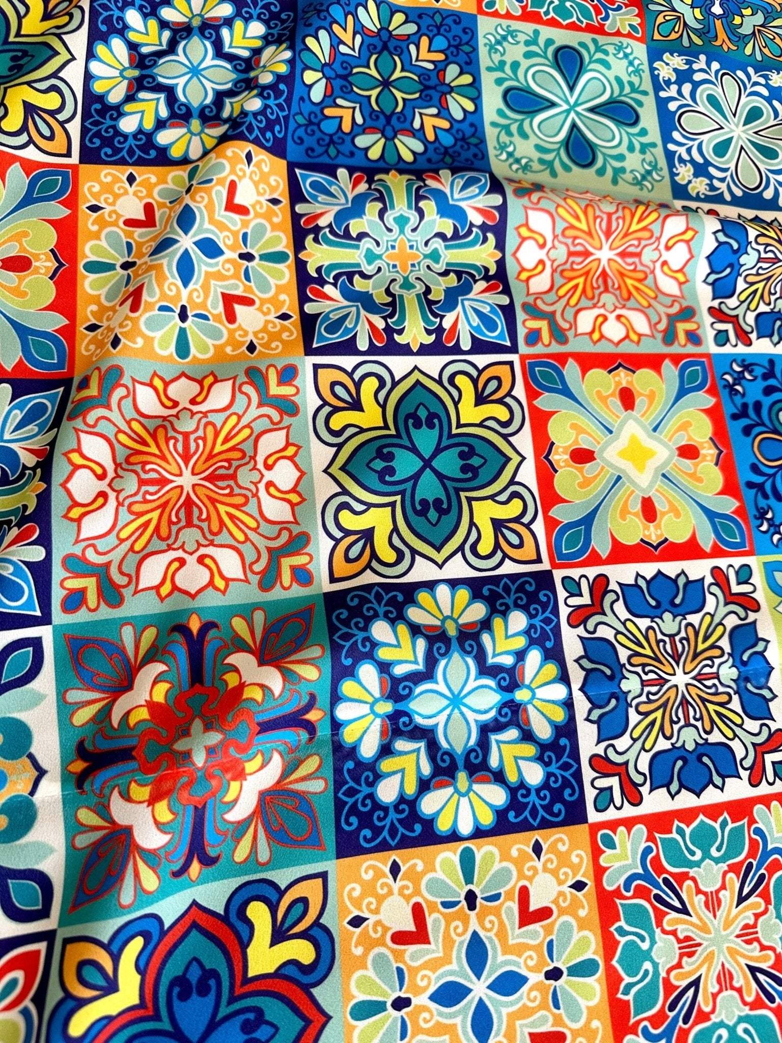 Colorful tile pattern fabric with decorative blue, orange, and yellow geometric designs for quilting and home decor projects