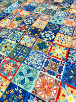 Colorful tile pattern fabric with various intricate floral and geometric designs in blue, orange, and yellow tones, suitable for quilting and home decor projects.