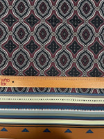 Burgundy and black geometric patterned fabric with ethnic striped edge and measuring ruler for scale