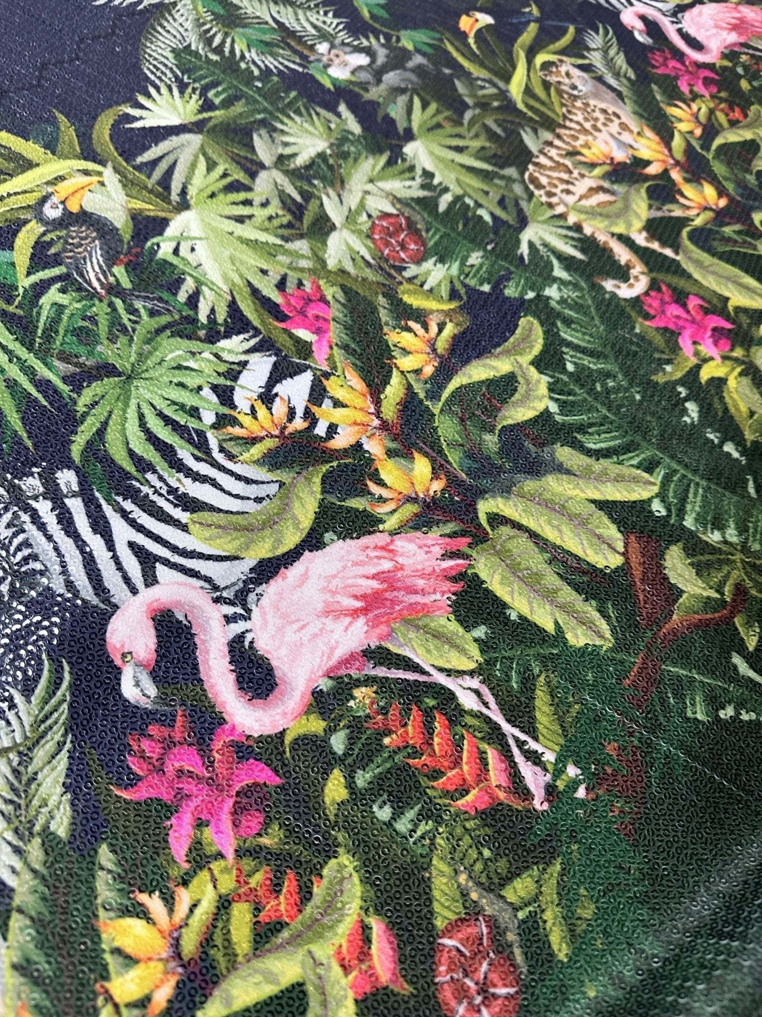 Tropical jungle print fabric with vibrant foliage, flamingos, toucans, and exotic animals on a dark background, featuring a 2-way stretch and sequin texture.