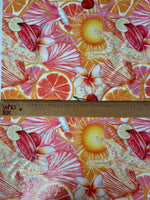 close-up of tropical citrus sequin fabric with vibrant orange, pink, and red starfish and floral patterns, showcasing 2-way stretch and sequin details