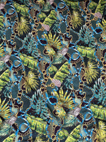 Tropical fabric with vibrant chain belt pattern featuring gold chains and green tropical leaves on a dark background