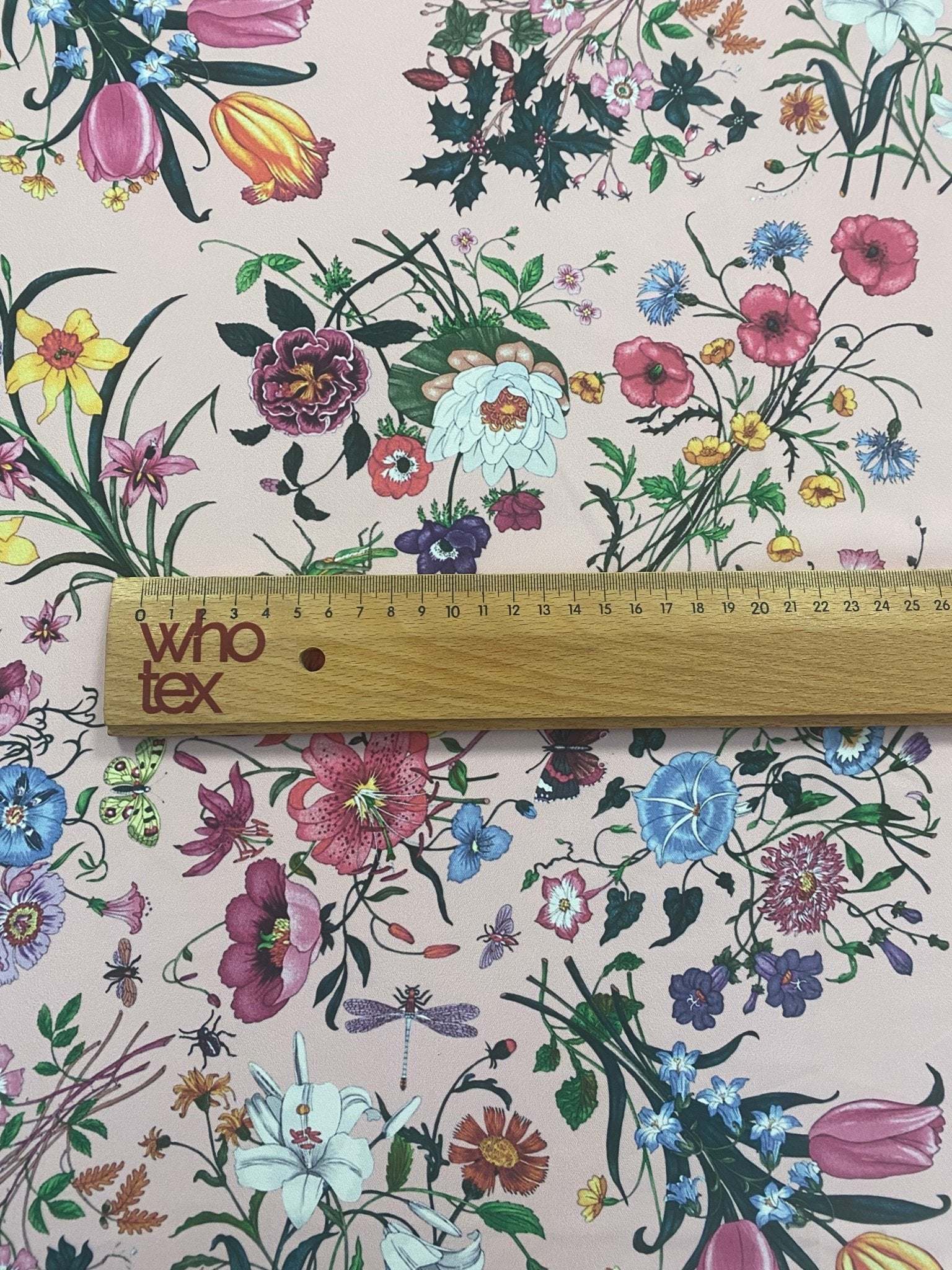 Vintage botanical floral print fabric with colorful flowers on cream background and wooden ruler for scale